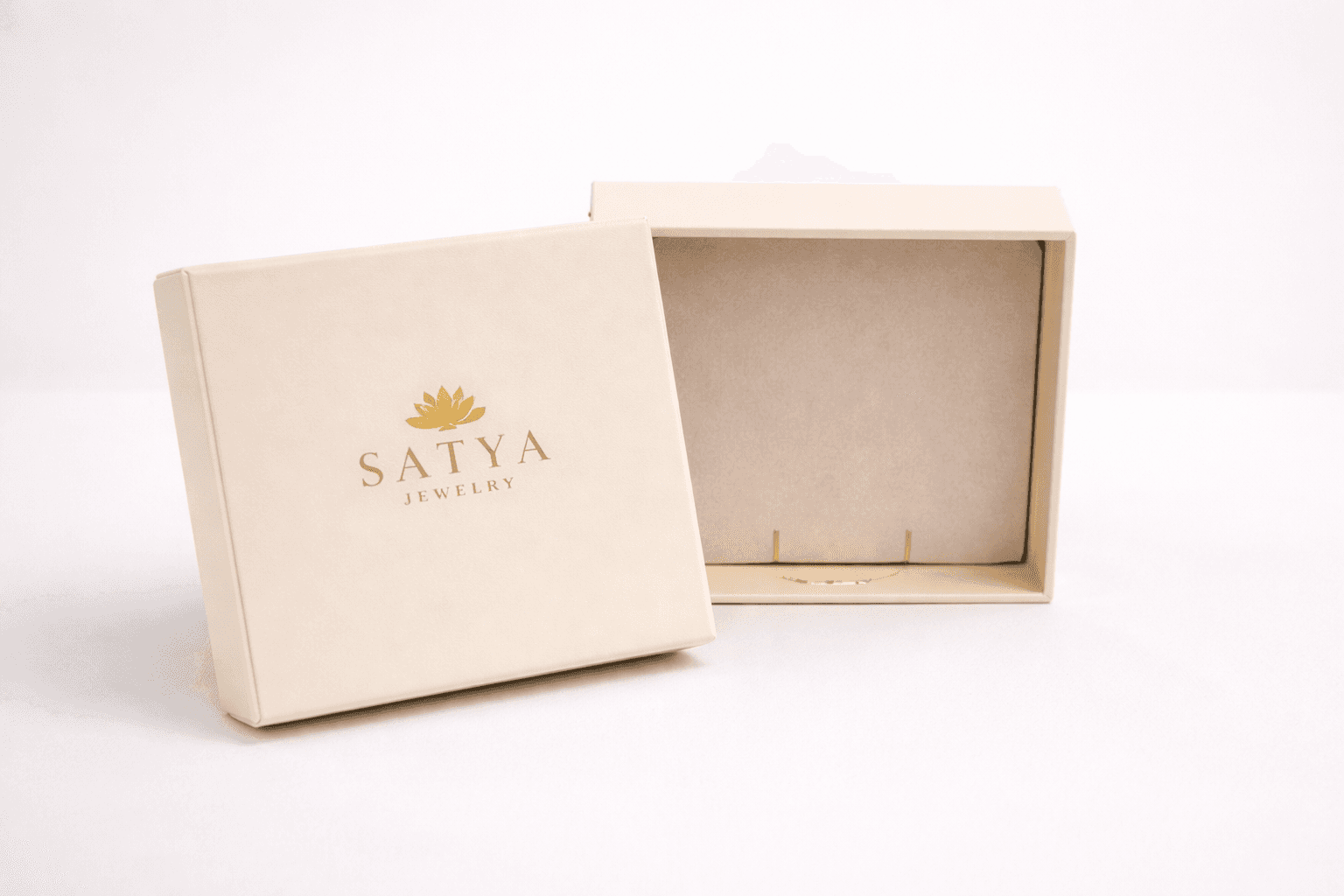 Cream-colored rigid jewelry box with gold foil logo and separate lid
