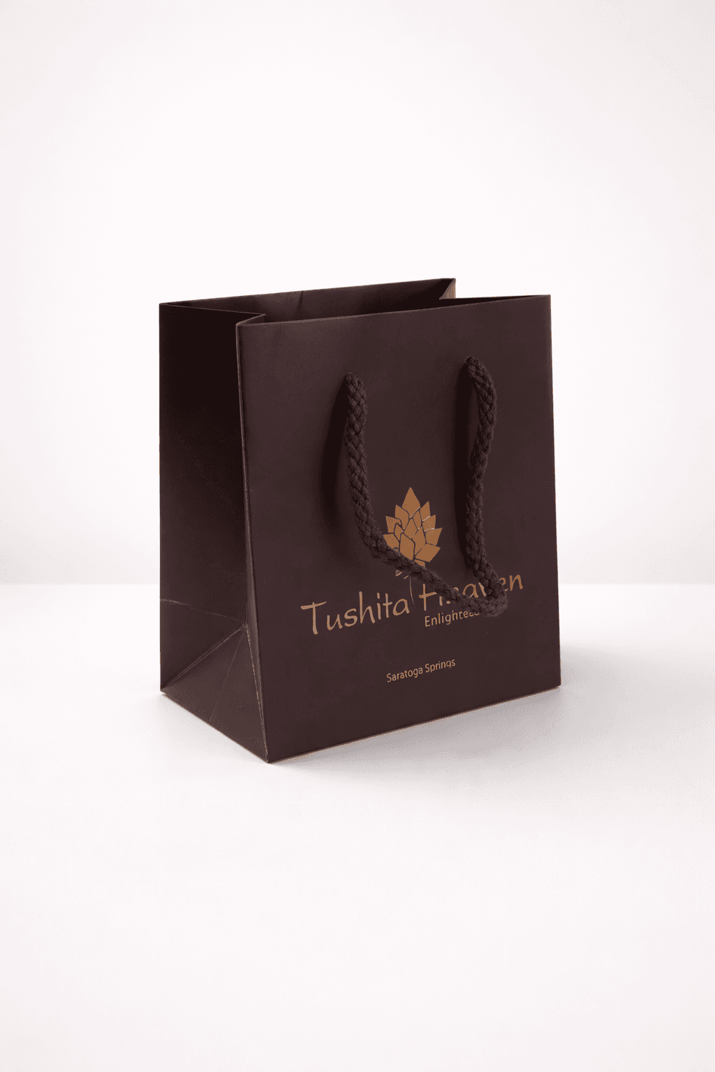 Brown paper eurotote bag with braided rope handles and gold foil logo